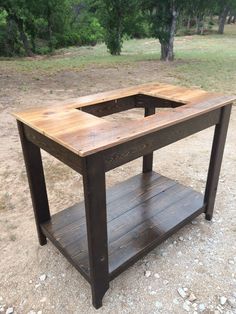 a wooden table sitting on top of a dirt field