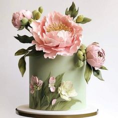 there is a green cake with pink flowers on it