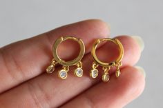 Dainty shaker earrings.Three round bezel set crystals dangle from small gold huggie hoops. Dimensions: earrings measure approximately 1.3 cm x 1.8 cm. Gold plated. Clear crystals. Huggie snap closure. Comes nicely wrapped in a jewelry box and ready to be gifted! All you need to do is put it in a gift bag. If you would like a note to be included in the package, just put your request in your order notes and I will make sure to include it! Affordable jewelry makes for a sweet gift for your best fri Dainty Round Hoop Earrings With Dangling Charms, Small Gold Hoops, Affordable Jewelry, Huggie Hoop Earrings, Gold Hoops, Modern Earrings, Chain Earrings, Round Earrings, Jewelry Plate