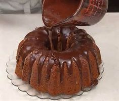 a chocolate bundt cake is being drizzled with icing