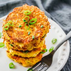 a stack of food sitting on top of a white plate next to a knife and fork