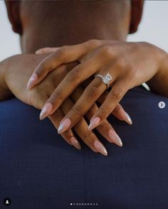 a close up of a person's hand with a diamond ring on their finger