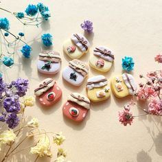 several decorated cookies sitting on top of a table next to flowers