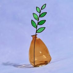 a glass vase with a green plant sticking out of it