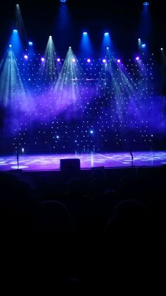 the stage is lit up with purple and blue lights as well as some spotlights