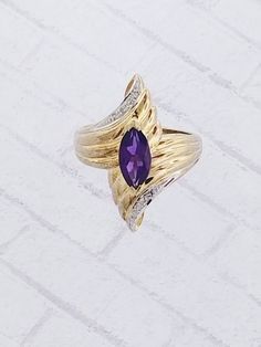 Vintage Amethyst & Diamond ring. Details: Size: US 6 1/2 ( Can be sized ) Weight: 4.4 grams Primary stone: Amethyst Stone Shape: Marquise ( Appx. 10mm x 5mm ) Secondary Stone: Diamond Stone Shape: Round Metal: 14k Yellow Gold Condition: Brand new Inside of band is stamped and tested for '14k' gold. SIZING: Currently this ring is a size 6 1/2 but could be sized up or down for an additional small fee if desired by adding custom ring sizing to your cart upon checkout. Most sizing can be done wi 14k Gold Purple Ring With Diamond Accents, Purple 14k Gold Ring With Diamond Accents, Fine Jewelry Purple Diamond Ring With Gemstone Accents, Purple Diamond Ring With Gemstone Accents, Fine Jewelry Purple Rings With Diamond Accents, Purple Rings With Gemstone Accents In Fine Jewelry Style, Fine Jewelry Purple Rings With Gemstone Accents, Purple Rings With Gemstone Accents Fine Jewelry, Purple Gemstone Accented 14k Gold Rings