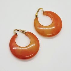 Vintage orange lucite chunky & wide hoop clip-on earrings Butterscotch color large mod hoops nonpierced earrings Statement Oversized Huge Earrings  It will be a great addition to your vintage jewelry collection. Don't miss out on these gorgeous earrings! 🔹 Unsigned. 🔹 Condition - the earrings are in very good pre-owned condition. All photos are taken in macro mode. Please look carefully at all the photos as they are part of the description to be in agreement with our offer. 🔹 Measure- 1 1/4 inch across, 1/2 inch wide. 🔹 Date: 1980. 🔹 Occasion- birthday, anniversary, party, or gift-giving for your special loved one. All jewelry has been professionally cleaned with jewelry cleaner in the ultrasound machine for cleaning; however, I recommend an alcohol bath before wearing them. Buy with Huge Earrings, Butterscotch Color, Summer Earrings, Summer Earring, Vintage Orange, Earrings Statement, Jewelry Cleaner, Jewelry Earrings Hoops, Gorgeous Earrings