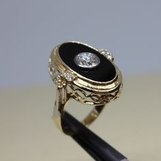 Fancy, vintage ring for women, in excellent condition made of 14k yellow gold, solid. Center approximately 0,80ctw plus, round shaped with approximate color F and VS1 clarity, burnished on on the center of Onyx, sized 11x18mm flat Onyx, complimented by a 4 small round shaped diamonds, two on each side, on prongs, approximate weight of which is 0,20ctw. Weight of the item is 6.7g, size 7 could be changed to. Please look at the all pictures and if you have any questions, ask, we will be happy to assist you. Ring will come in a very nice gift box, that will make it look even more special for asomeone you love. Thank you for shopping with us. Round Black Enamel Diamond Ring For Anniversary, Black Enamel Diamond Anniversary Ring, Vintage Formal Dome Ring, Black 14k Gold Diamond Ring, Black 14k Gold Rings With Brilliant Cut, Oval Black Enamel Rings For Anniversary, Antique Black Round Signet Ring, Heirloom Black Round Cut Ring, Classic Black Diamond Ring Stamped 14k