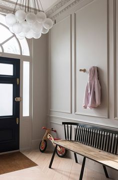 a wooden bench sitting in front of a door next to a black and white door