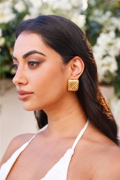 18k gold plated. Earrings. Textured design. Stud closures for pierced ears. Please Note: Avoid contact with lotions and perfumes. For lovers of luxe. The 18k Gold Plated Cushions Earrings feature a textured design with a gleaming gold finish. Style with all your 'fits for an elevated. sophisticated look.