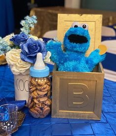 a cookie box with cookies in it and a blue stuffed animal sitting next to it