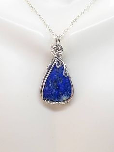 📌Handmade Item📌 💘Lapis Lazuli Sterling Silver Wire Wrapped Pendant is crafted using a Argentium fine silver wire that is wrapped around a gorgeous deep blue lapis lazuli stone with a rose in the middle. 💘This beautiful pendant is 1.62 inches high by .79 inches in width. Comes with either a free 18 or 20-inch sterling silver starter chain or a waxed leather cord as a gift for your purchase. 💘Aesthetic Jewelry will make a timeless gift for her and the perfect romantic gift. All pendants are s Handmade Lapis Lazuli Necklaces, Handmade Blue Lapis Lazuli Necklace, Unique Handmade Sapphire Necklace, Unique Sapphire Necklace As Gift, Unique Sapphire Necklace For Gift, Artisan Lapis Lazuli Necklace Gift, Handmade Sapphire Round Pendant Necklace, Unique Handmade Silver-plated Wire Jewelry, Handmade Sapphire Necklace With Round Pendant