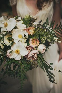 a woman holding a bouquet of flowers in her hands