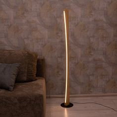 the floor lamp is lit up in front of a couch