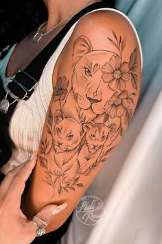 a woman's arm with an animal tattoo on it and flowers around the arm