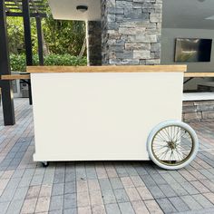 an ice cream cart sitting on the side of a road next to a stone building