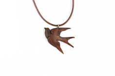 a wooden bird pendant hanging from a leather cord