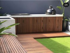 a hot tub sitting on top of a wooden deck next to a green planter