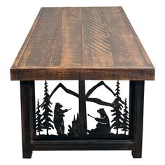 a wooden table topped with metal animals and pine trees on it's sides in front of a white background