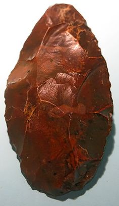 a piece of red rock sitting on top of a table