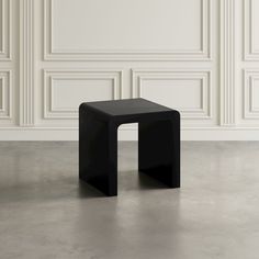 a black table sitting in front of a white wall