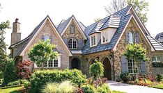 a house with many windows and plants in the front yard