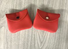 two red purses sitting on top of a wooden floor