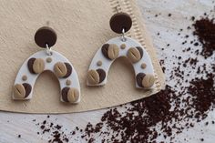 two brown and white giraffe shaped earrings sitting on top of a piece of paper