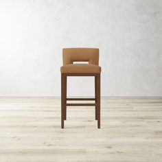 a tan leather bar stool with an upholstered seat and back rests against a white wall