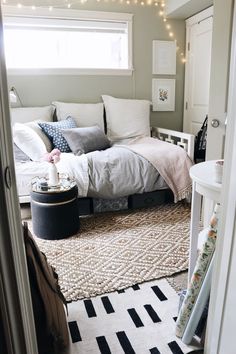 a bedroom with a bed, rugs and lights in the window sill above it