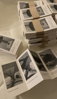 a stack of folded books sitting on top of a white table next to each other