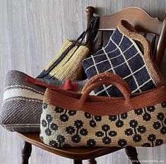 several purses sitting on top of a wooden chair