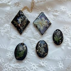 four pieces of jewelry sitting on top of a white cloth