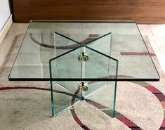 a glass coffee table with metal accents on top