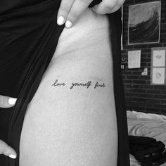 a woman's stomach with the words love yourself not written in cursive font