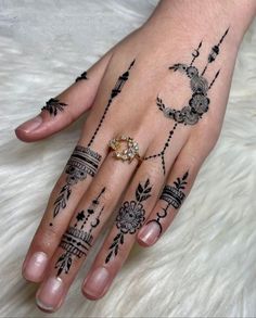 a woman's hand with hennap tattoos on her left hand and ring