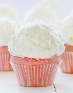 several cupcakes with white frosting and a spoon