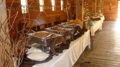 several buffets are set up on a long table in a room with wood paneling