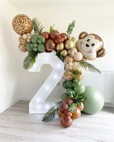 the number two is decorated with balloons and jungle animals