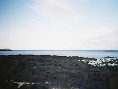 there is a rock outcropping with the ocean in the background