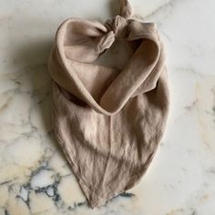 a tan scarf laying on top of a marble counter