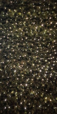 an aerial view of the top of a christmas tree at night with lights on it