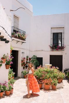 a woman standing in front of some potted plants