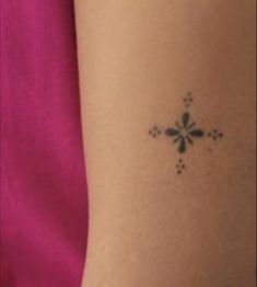 a woman's arm with a small tattoo design on the left side of her arm