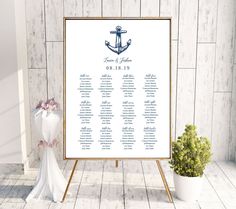 a wedding seating chart with an anchor and cross on the front, next to a potted plant