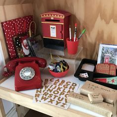 a desk with various items on it including an old phone, letterpresss and other office supplies