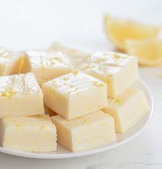 a white plate topped with pieces of cake next to sliced lemons