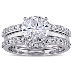 a white gold engagement ring set with an oval cut diamond surrounded by round brilliant diamonds