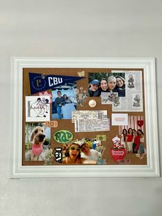 a cork board with pictures and magnets attached to the back of it in a white frame