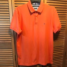 Orange Slim Fit Polo Shirt With 2 Button Front, Logo On The Left Front, Ribbed Collar And Cuffs And Splits On The Sides. Size Xl. Measures 24” From Underarm To Underarm And 32” From Shoulder To Bottom. 97% Cotton 3% Elastane. Nwt Solid Spring Polo Shirt With Button Closure, Solid Polo Shirt With Button Closure For Spring, Casual Spring Polo Shirt With Button Closure, Classic Orange Short Sleeve Shirt, Classic Orange Tops For Spring, Classic Orange Buttoned Top, Classic Orange Collared Top, Classic Orange Tops With Buttons, Fitted Casual Tommy Hilfiger Shirt